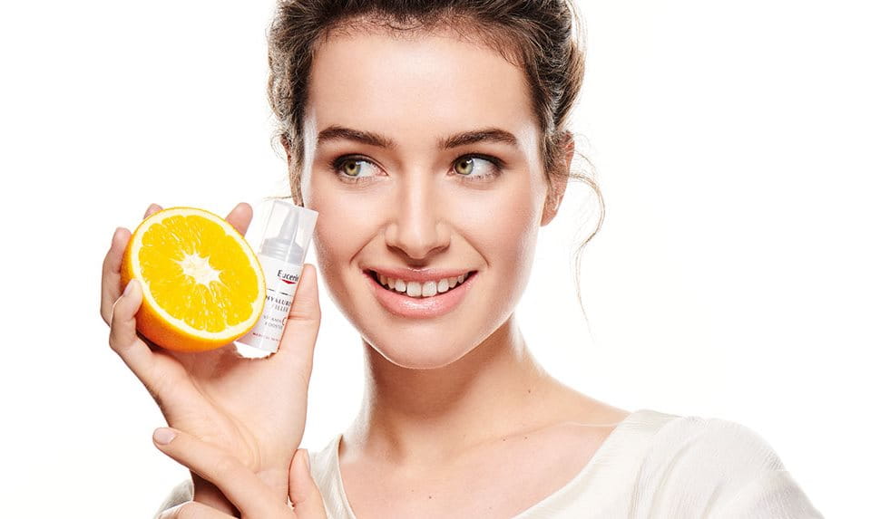 žena s narančom i Eucerin Vitamin C njegom