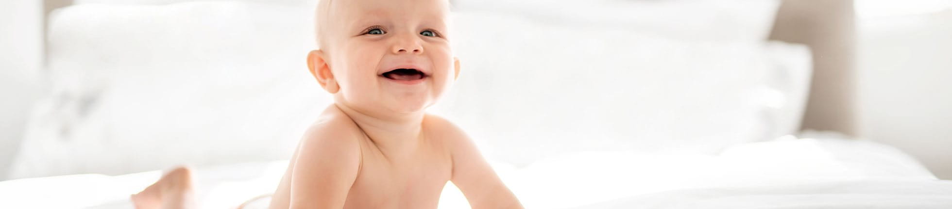 Baby in Windel auf Bett