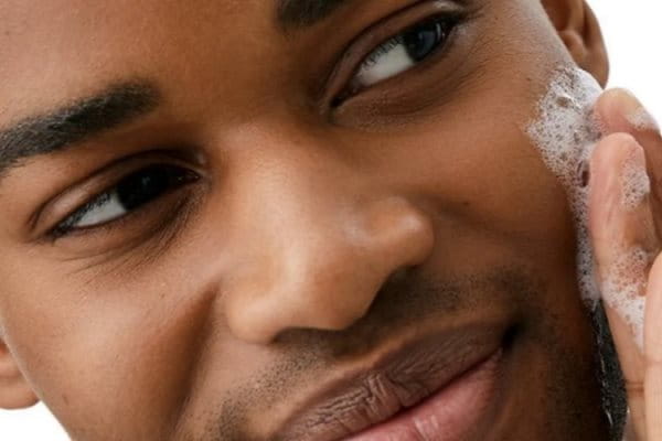 Frau nutzt Acne Creme im Gesicht