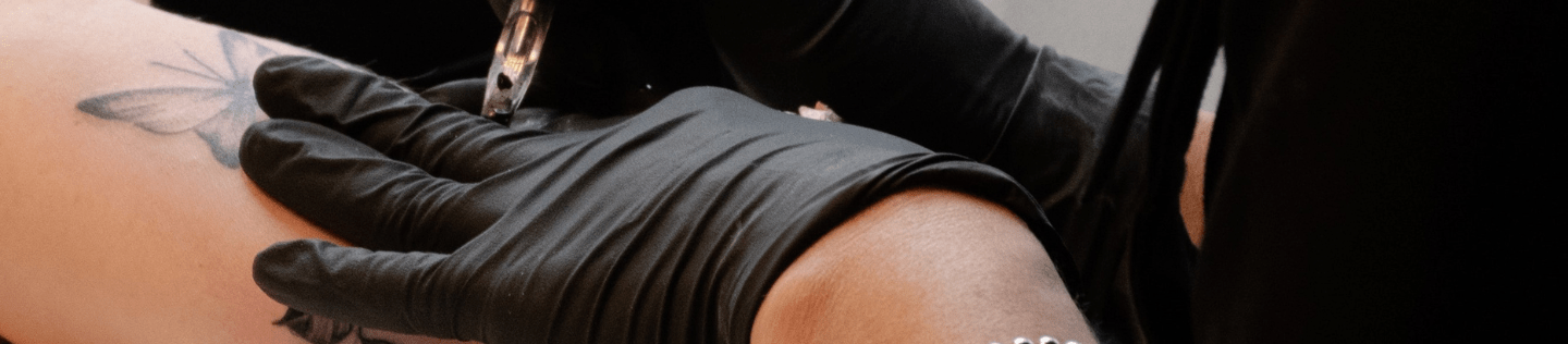 tattoo artist tattooing a persons arm