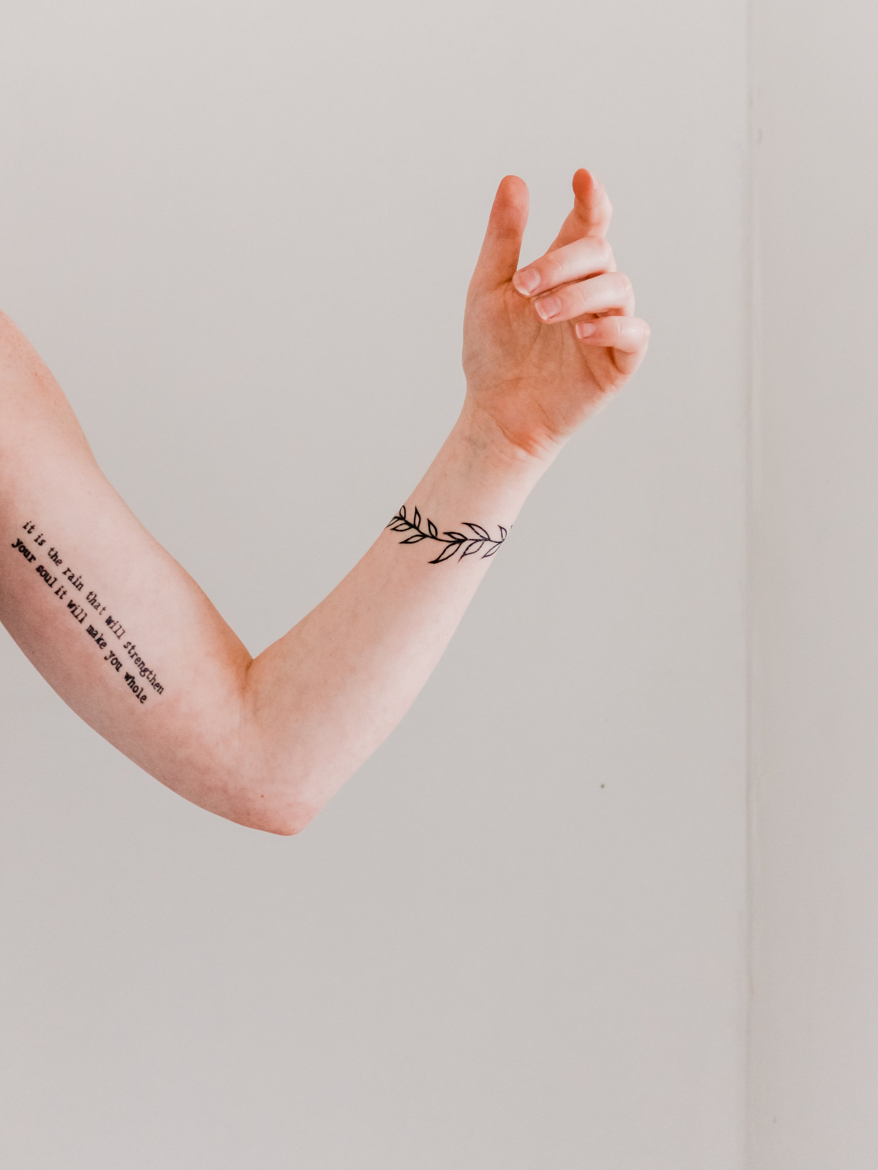 En tatuerad arm mot en grå bakgrund