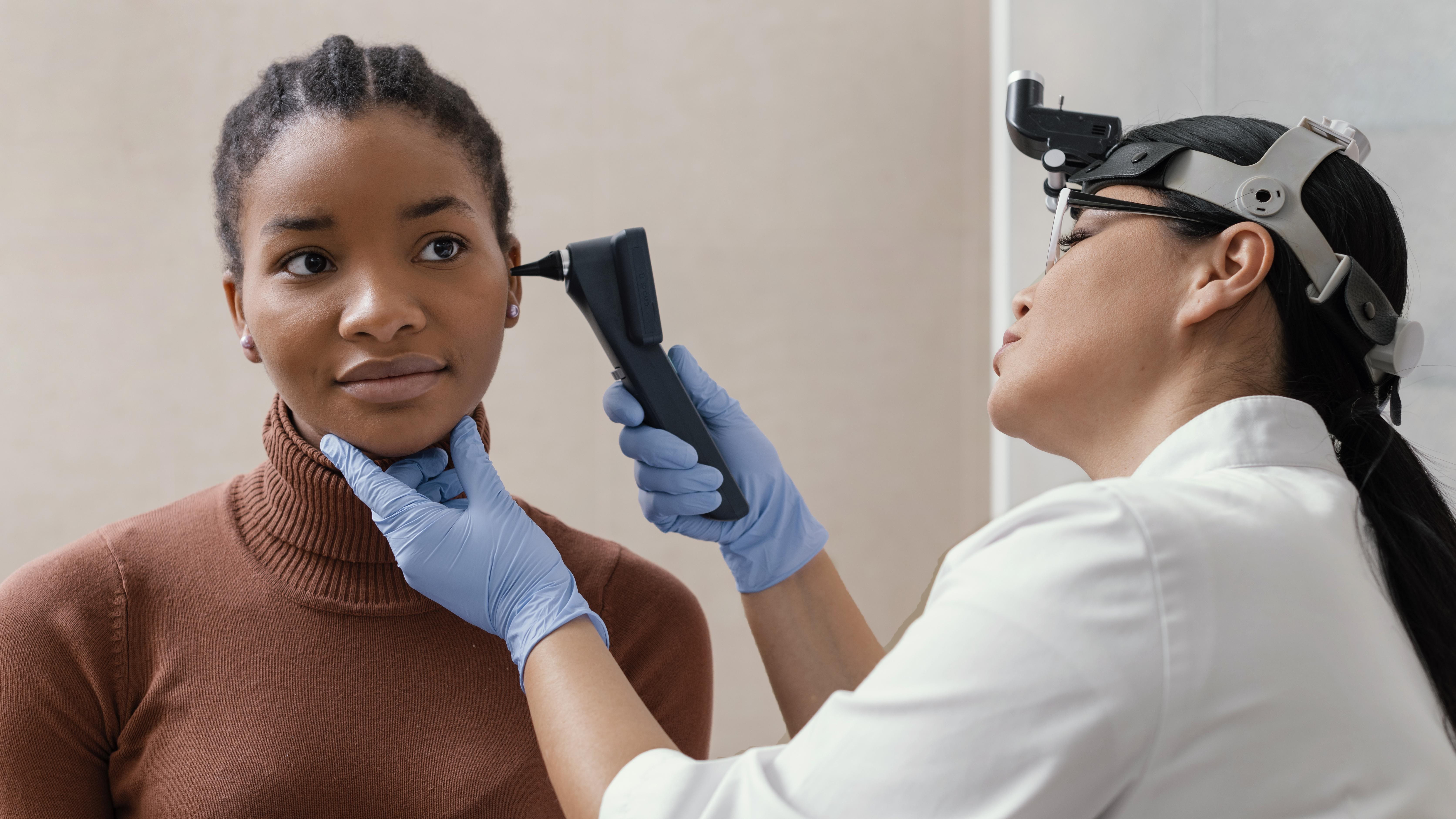 A doctor is checking a woman's ear