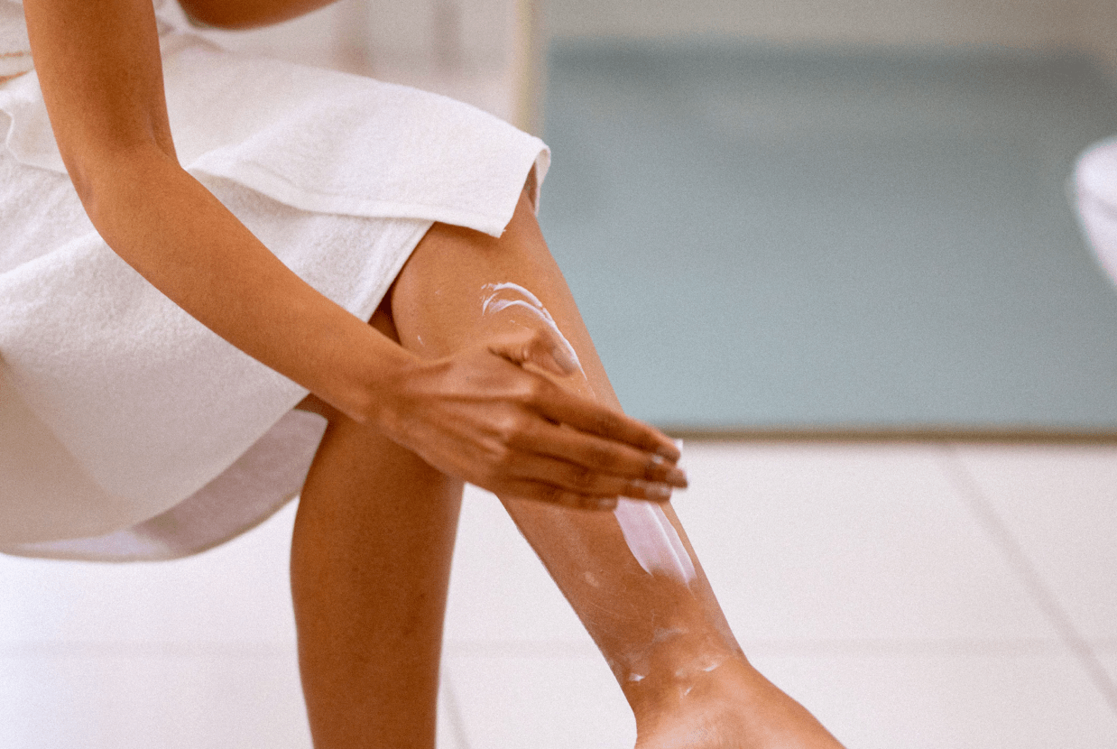 A women applying moisturiser to itchy legs after a shower