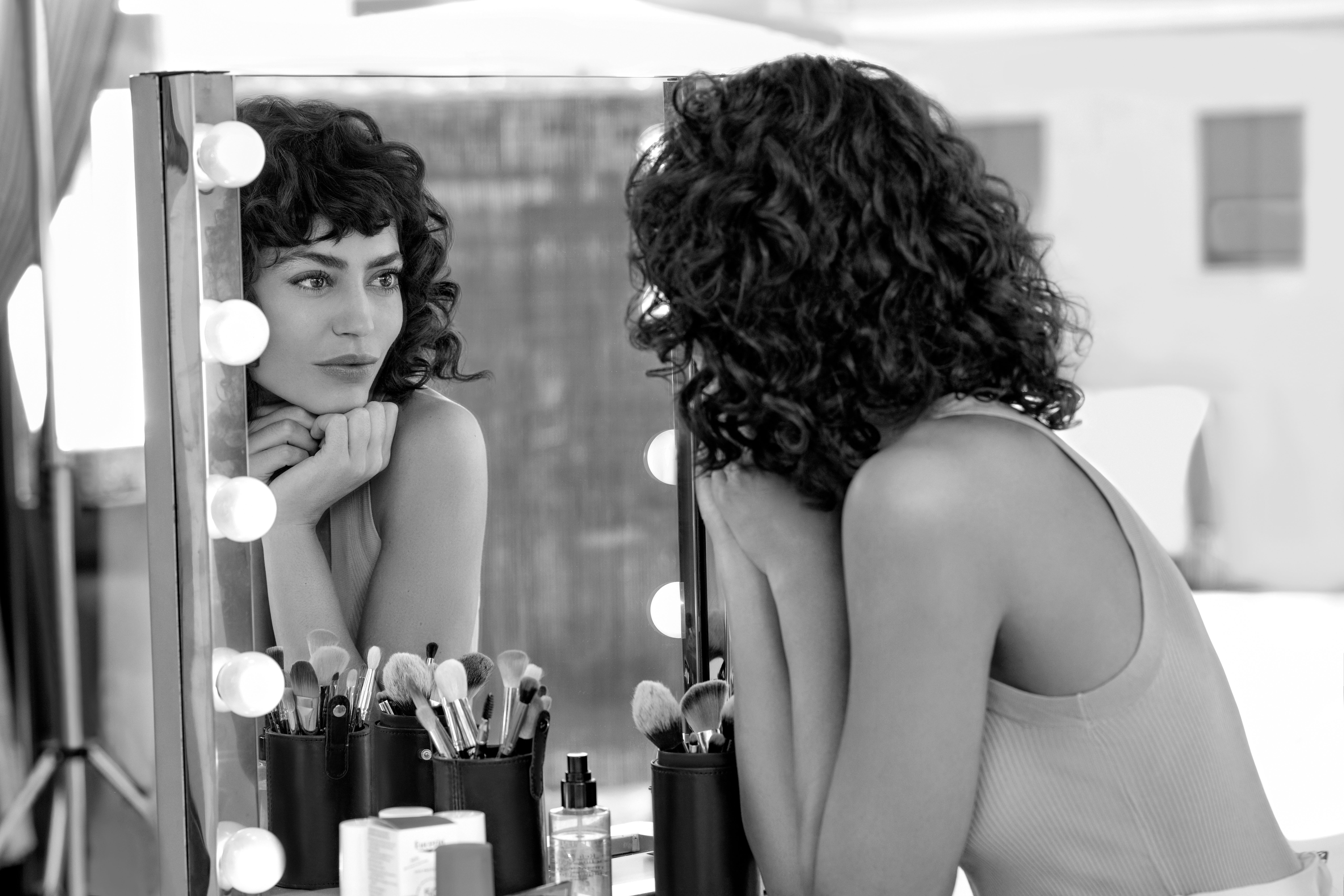 Woman looking at her own reflection in mirror