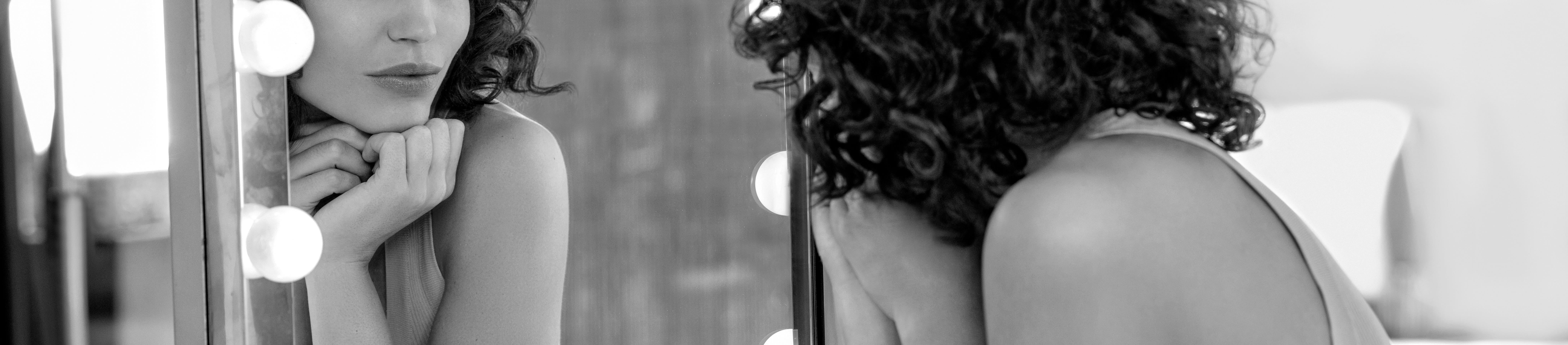 Woman looking at her own reflection in mirror