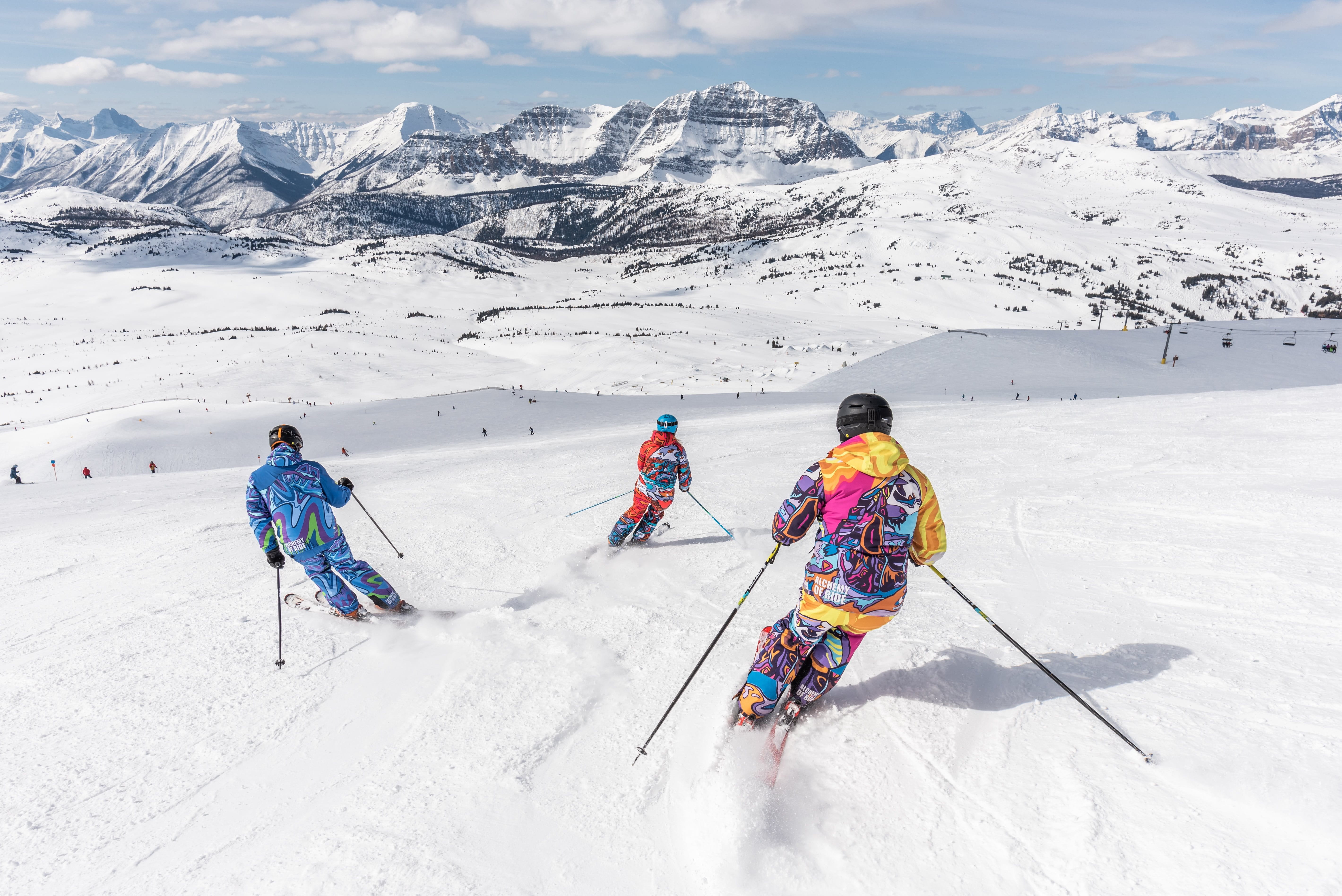 three skiers on a mountain, avoiding ice burns by wearing appropriate clothing