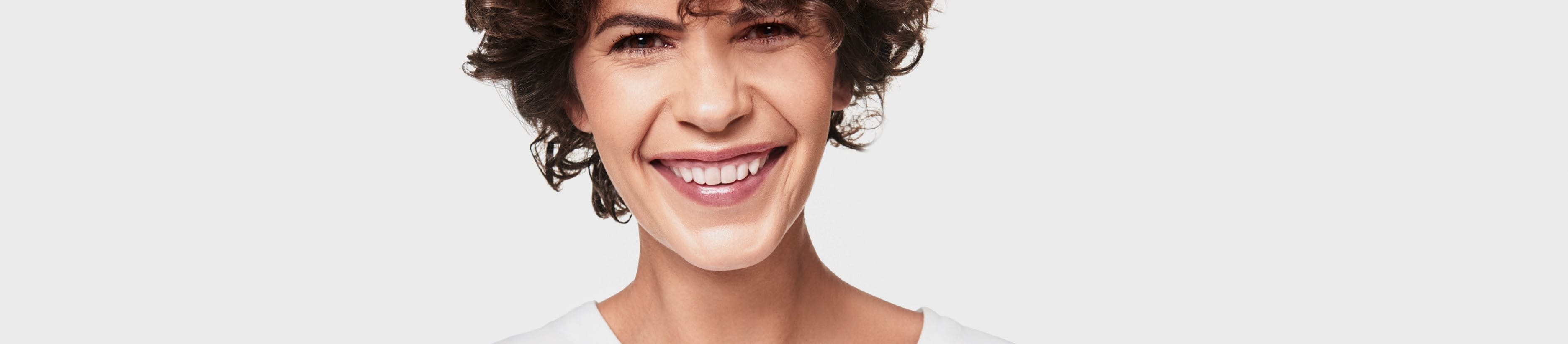 leende kvinna mot grå bakgrund