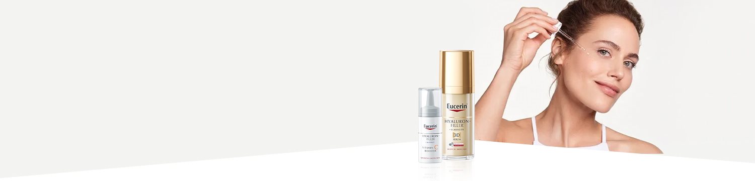 Žena používajúca sérum na pleť a dva Eucerin produkty