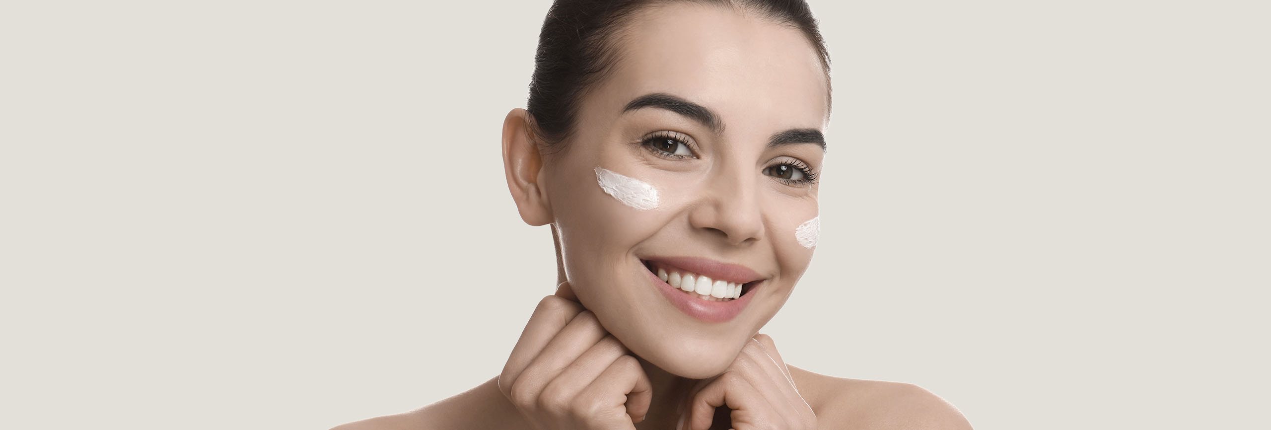 Mujer sonriente con cremas en la cara