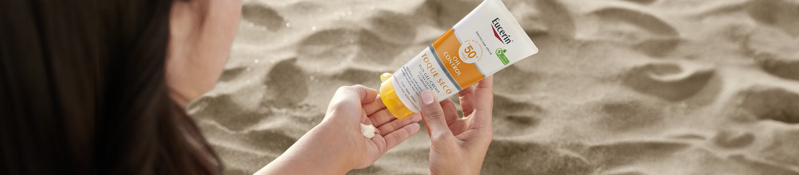 Persona aplicando protección solar para cara y cuerpo