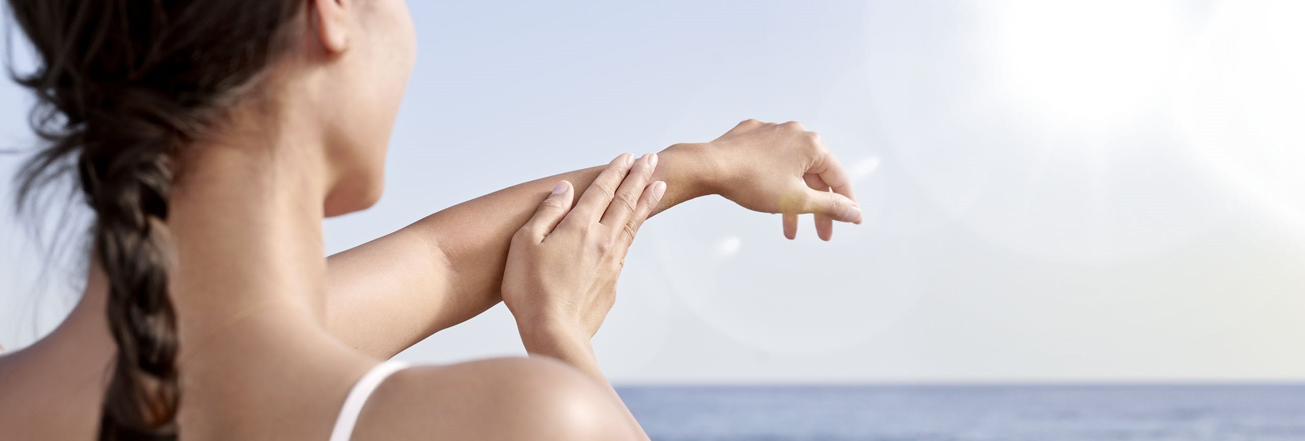 Mujer cuidando su piel de los efectos de los rayos UV en la piel