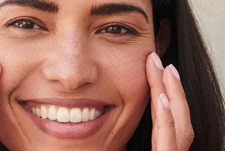 Mujer colocando protector solar encima de maquillaje