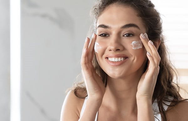 Mujer aplicándose crema hidratante facial