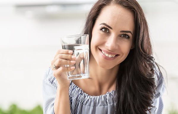 Mujer hidratándose con agua