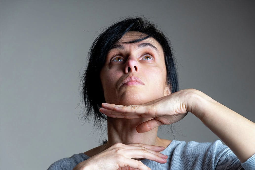 foto di donna che effettua ginnastica facciale per eliminare il doppio mento