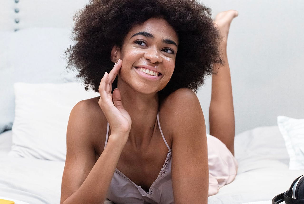 woman rubbing cream on face