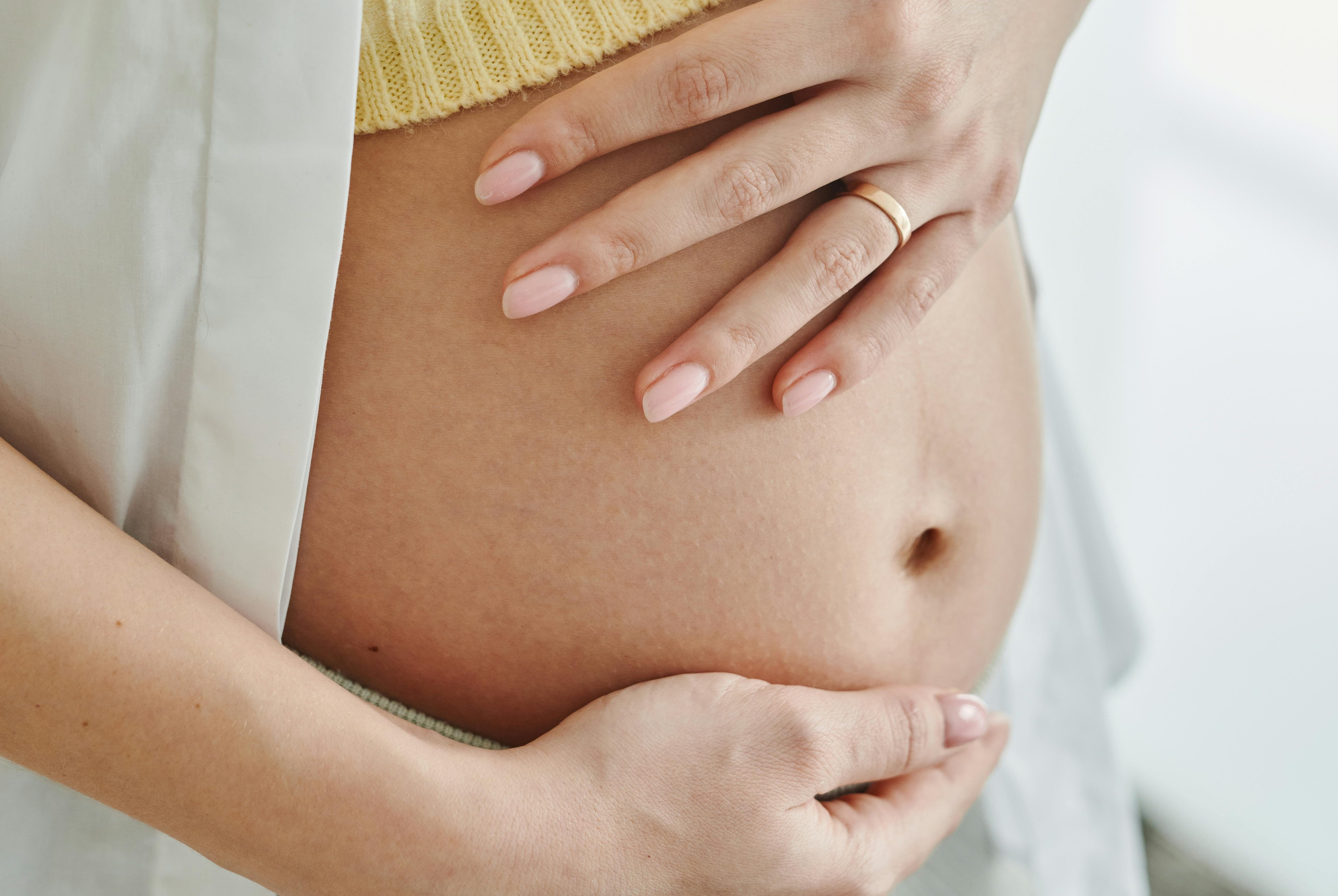 en gravid kvinna som håller om magen