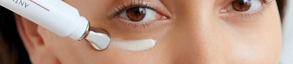 Kvinna som applicerar ögonkräm