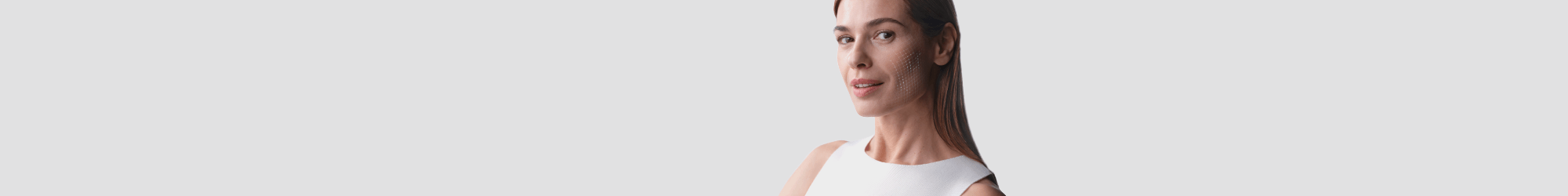 Une femme en chemise blanche sans manches sur fond gris