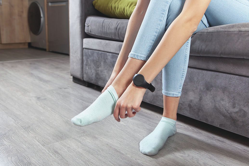  Persona seduta sul divano mentre sostituisce i calzini in cotone