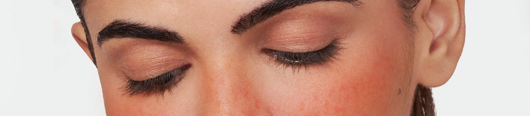 kuva punaisilla poskilla alas katsovasta naisesta