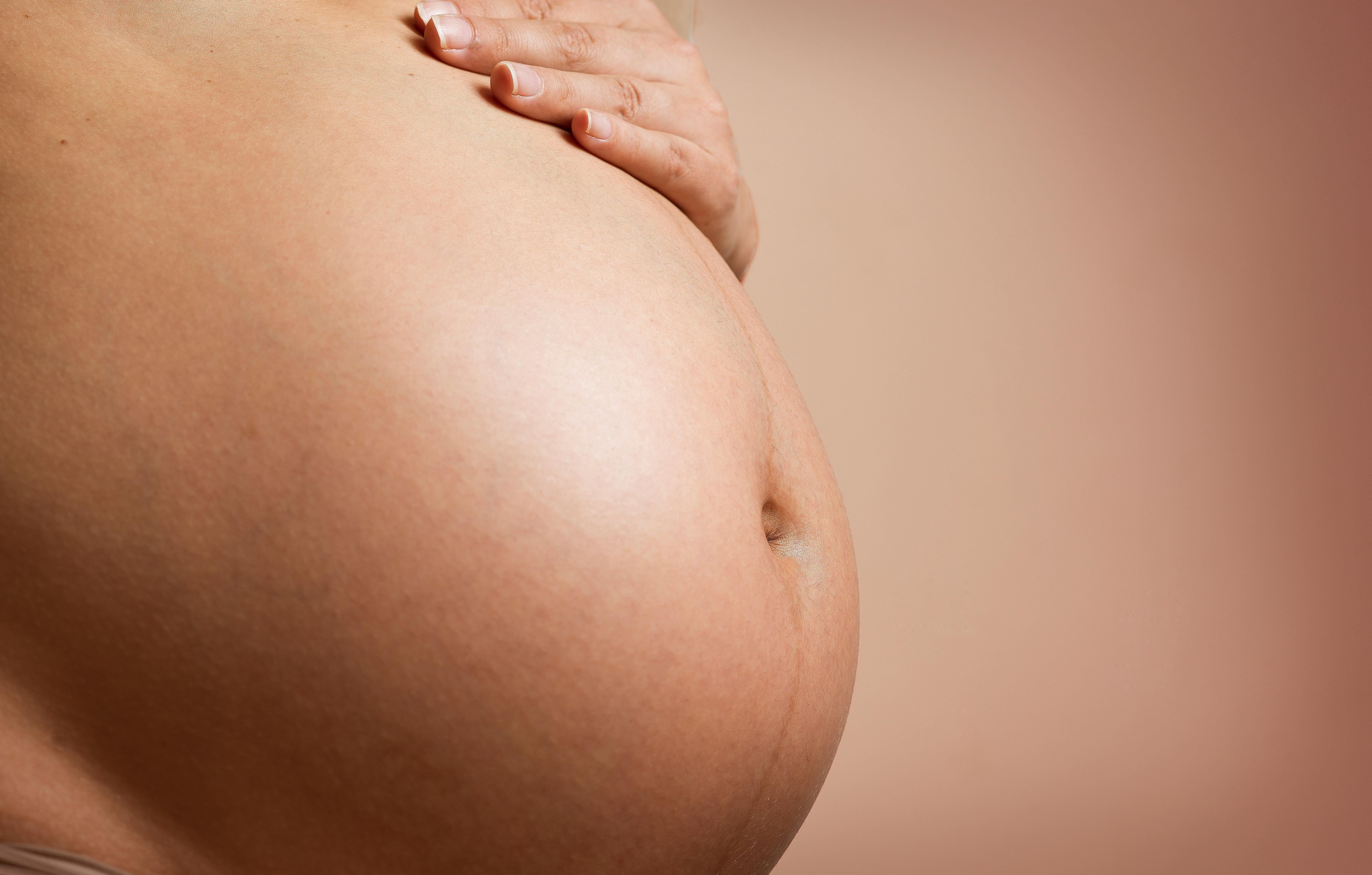 Schwangere Frau die sich ihren Bauch hält.