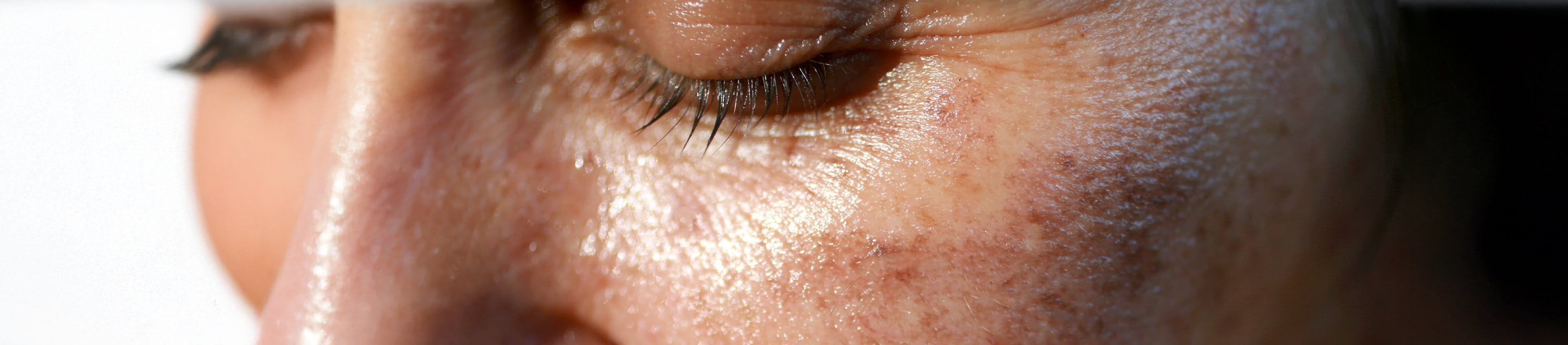 Frau cremt sich das Gesicht ein