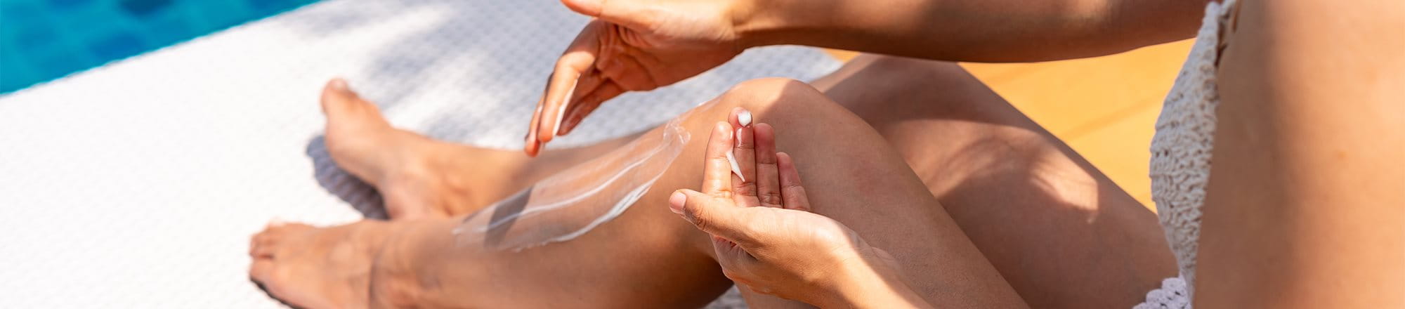 žena používající opalovací krém na nohy