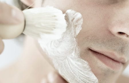 men applying shaving cream on face