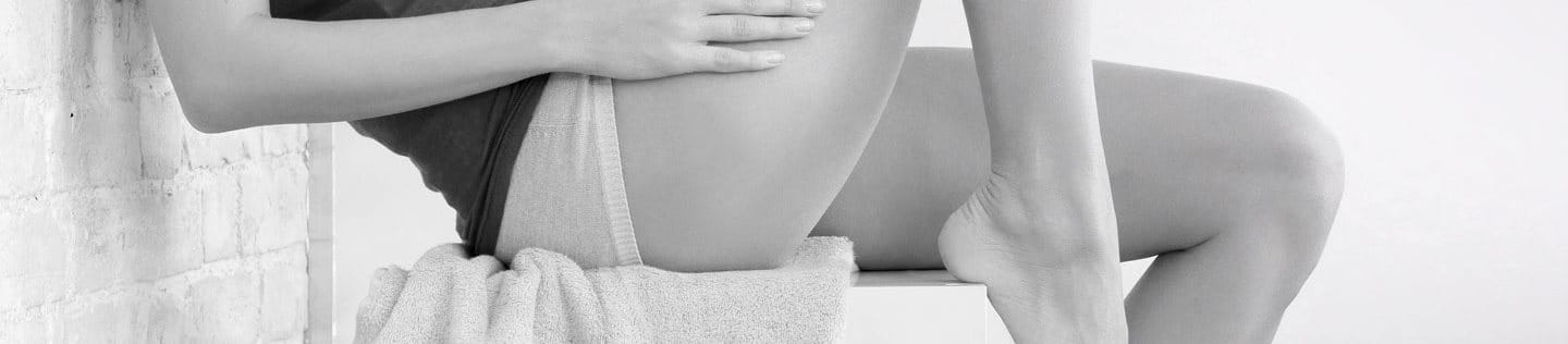 Woman’s body sitting – her arm on her thigh