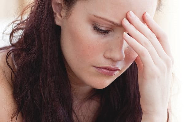 A woman holding her face with a stressed look