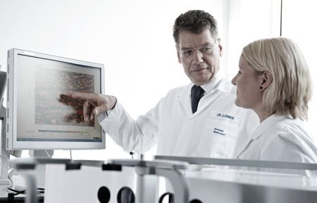 Two scientists in laboratory looking at a monitor