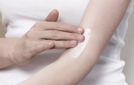 Vrouw smeert AtopiControl Intensief Kalmerende Crème tegen jeuk in elleboogplooi