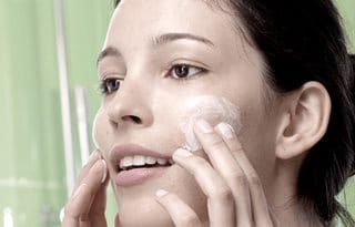 Women using Cleanser on cheeks 