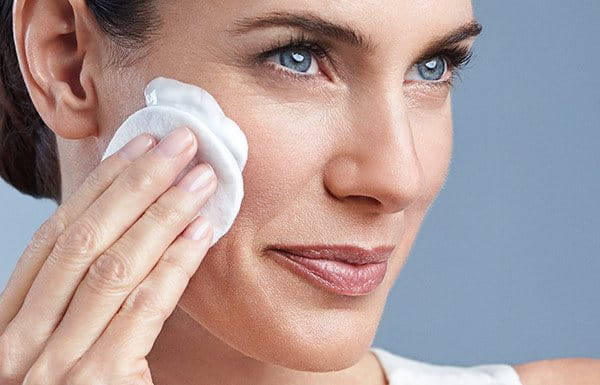 Жена със зряла кожа почиства лицето си