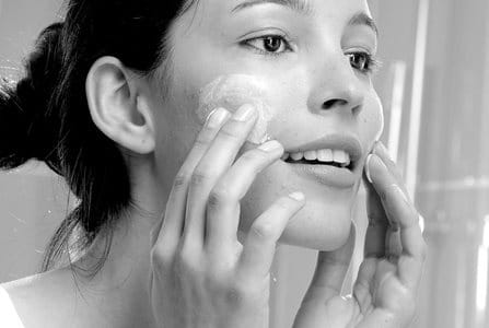 Woman appliying cream on her face