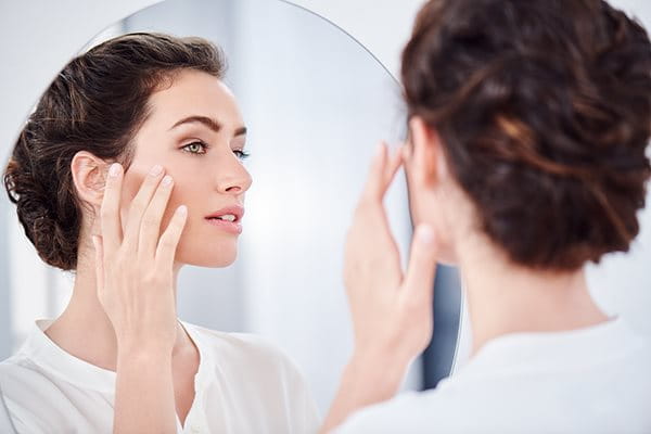woman applying hyaluronic acid to face