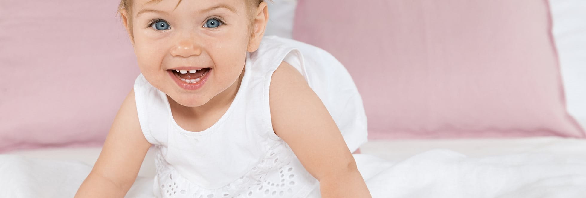 Baby in white dress smiling