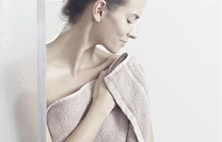 Woman patting her skin dry after showering,