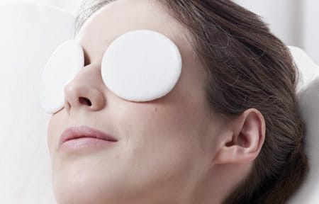 Woman relaxing with eye pads on both eyes.