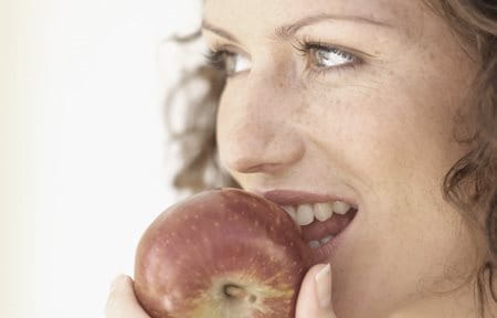 Woman eating a red apple