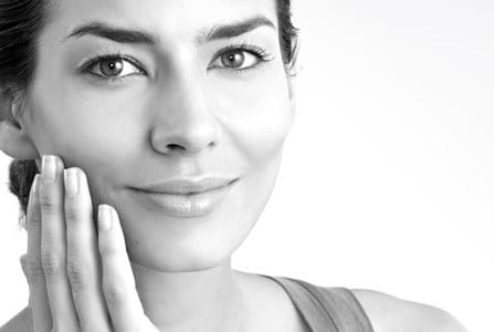 Middle-aged woman touching her right cheek with hand