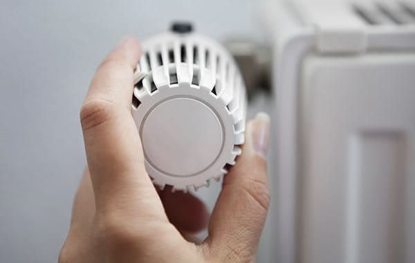 Woman turning on heater