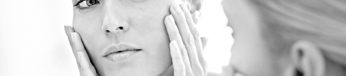 Woman with hypersensitive skin looking in the mirror