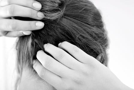 A woman scratching her itchy scalp