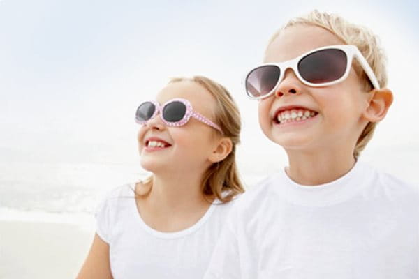 Barn som bär solglasögon för att skydda ögonen.