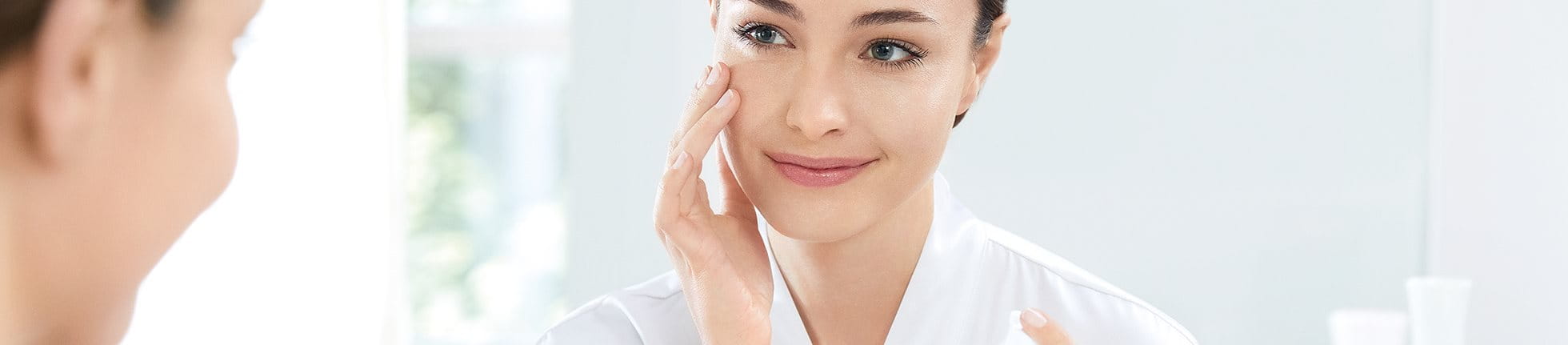 Mulher aplicando creme facial Eucerin