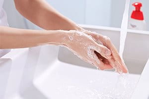 Hände werden unter einem Wasserhahn gewaschen   