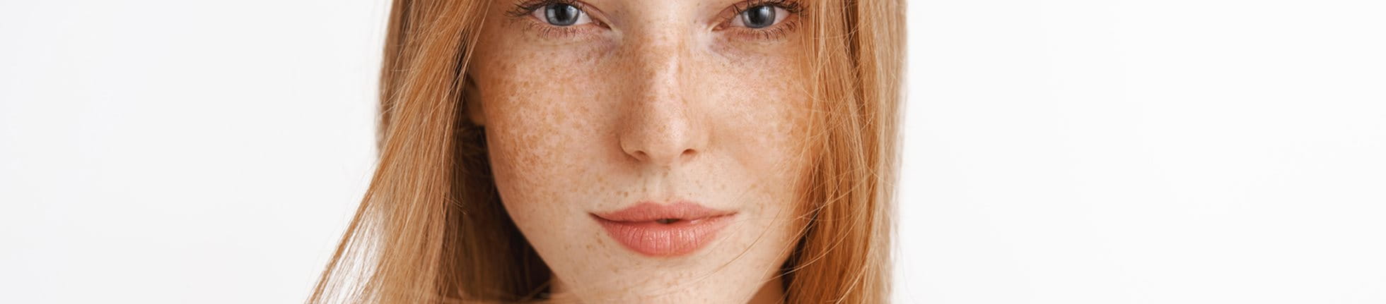 Femme aux cheveux roux avec des taches de rousseur sur le visage.