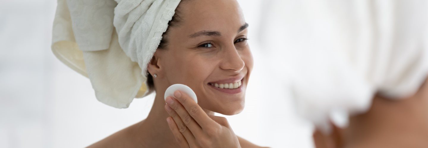 Eine junge Frau reinigt das Gesicht mit Salicylsäure.